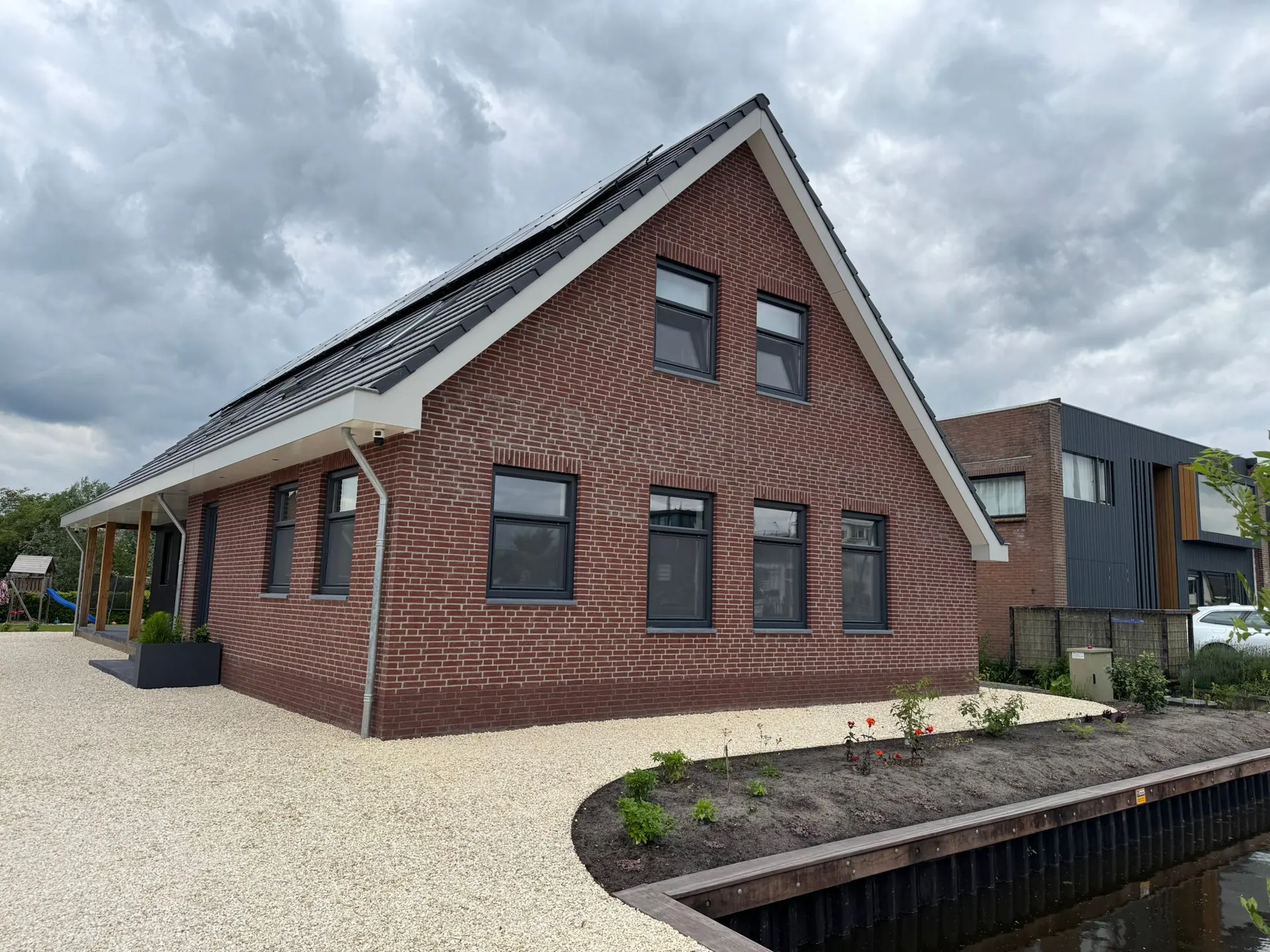 Nieuwe woning met antracieten kunststof kozijnen en een donker pannendak